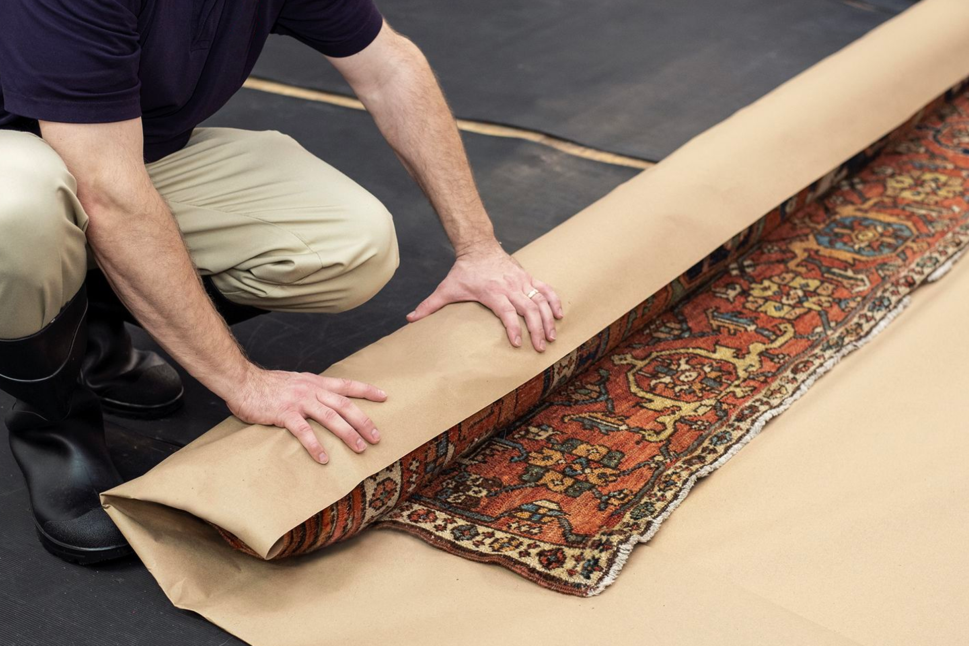 Rug being carefully rolled and loaded for transport